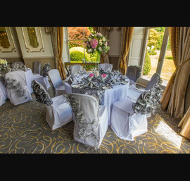 A Wedding Reception in Argent D'Or - Alternating Silver Floral Veils with Silver Frilled Caps on White Chair Covers with matching White Table Linen