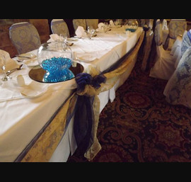 Midnight Blue and Champagne Flock Organza Sashes tied with Pearls on White Chair Covers at Langley Castle with matching Top Table Swagging