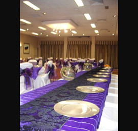 Black and Cabury's Purple Double Organza Bows on White Chair Covers and Cadbury's Purple Pintuck Overlays with Black Damask Runners and Silver Charger Plates at North Lakes Hotel