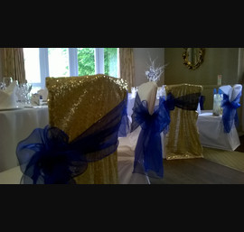 Gold Sequin Chair Veils with Blue Organza Sashes on White Chair Covers