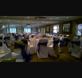 Gold Sequin Chair Veils with Blue Organza Sashes on White Chair Covers